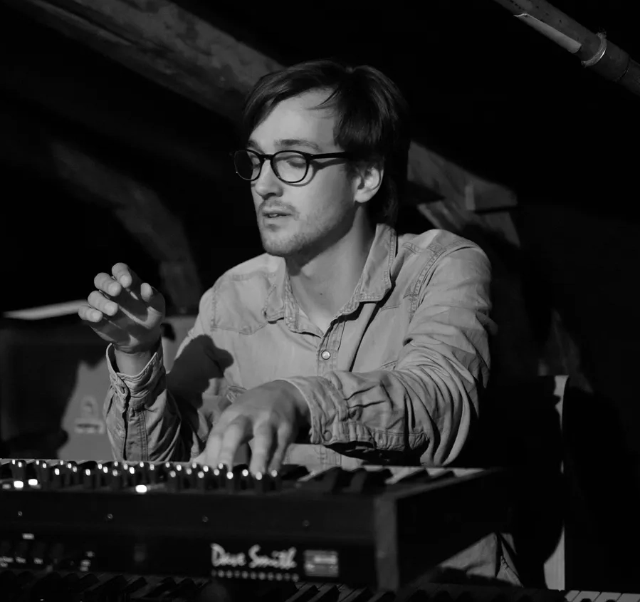 Daniel personporträtt av Daniel sittandes vid en synth