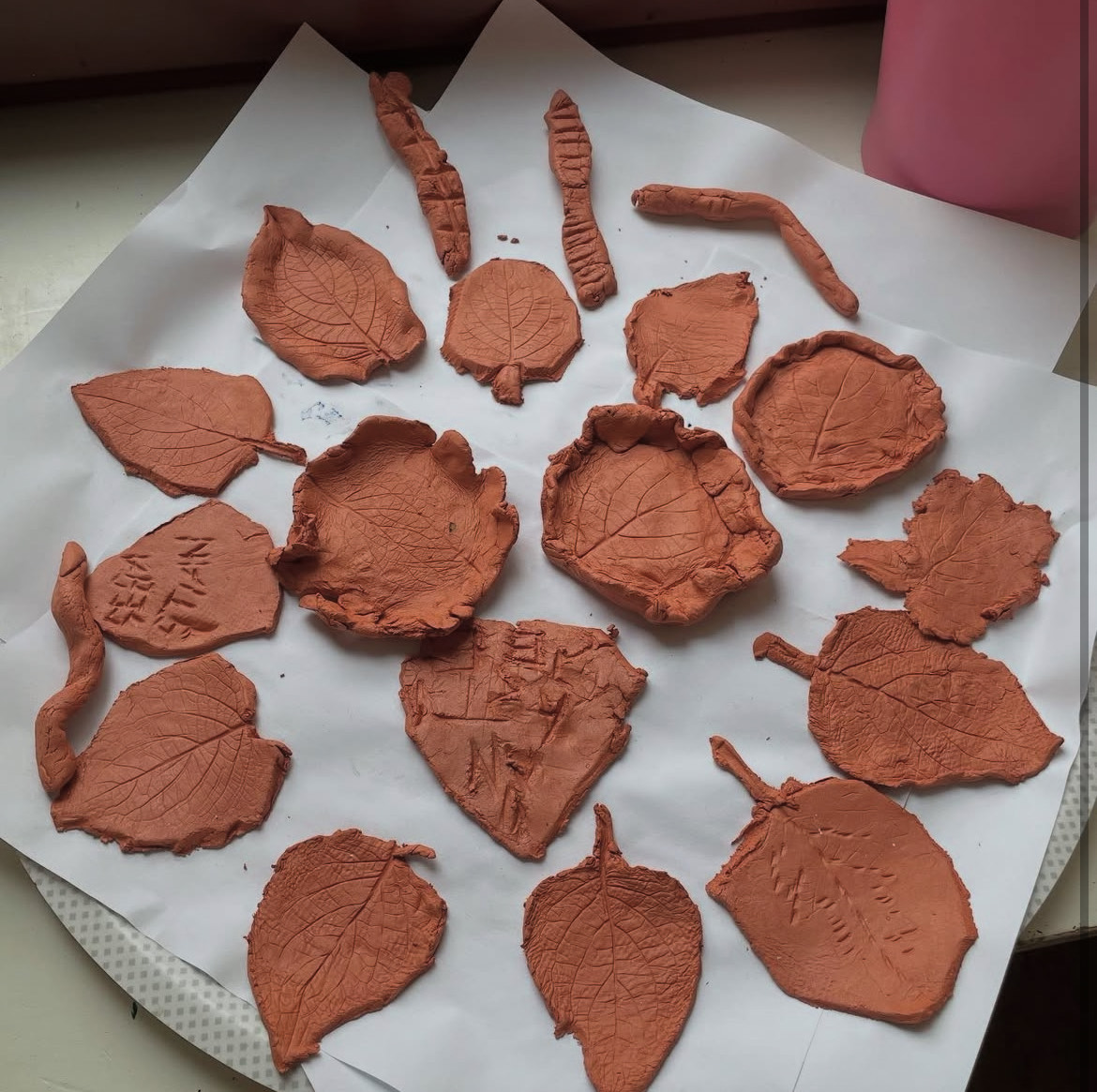 En bild av löv utformade av röd lera